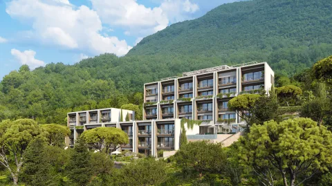 Pogled na moderno stambeno zdanje okruženo zelenilom i planinskim pejzažom. - image 6