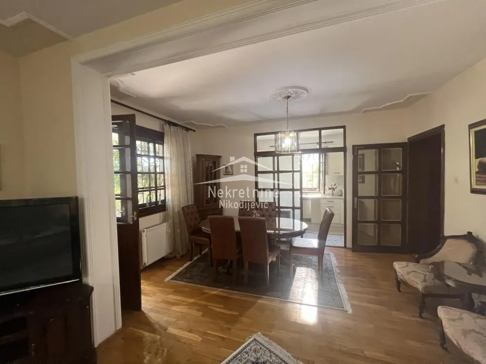 Spacious living room with a dining area and wooden furniture.
