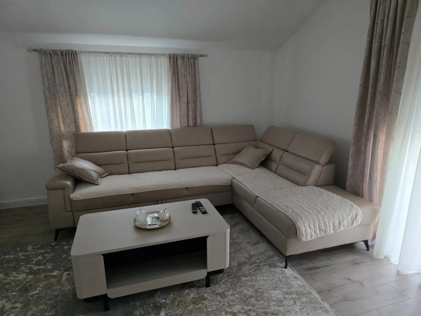 Dnevna soba sa ugaonom garniturom i stočićem.