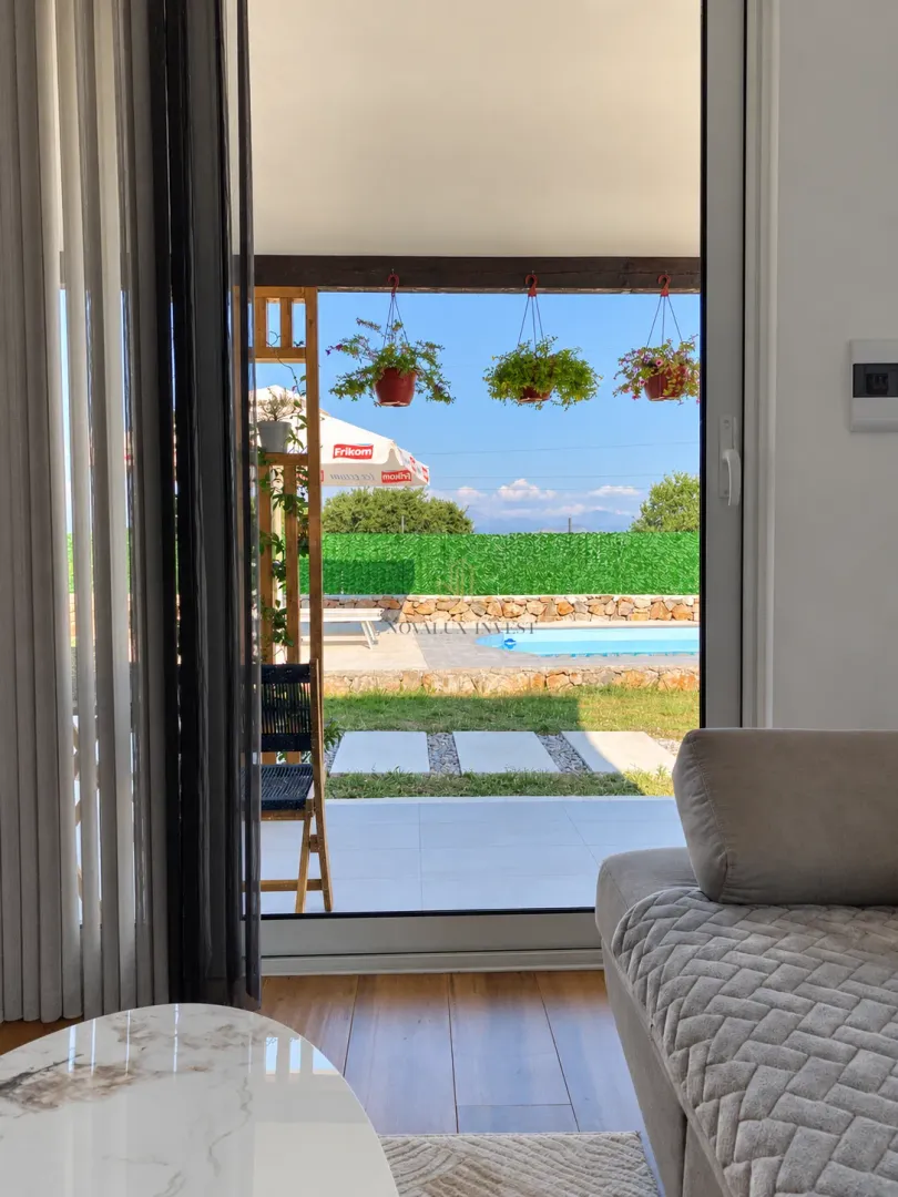 View from the living room to the terrace and courtyard with a swimming pool.