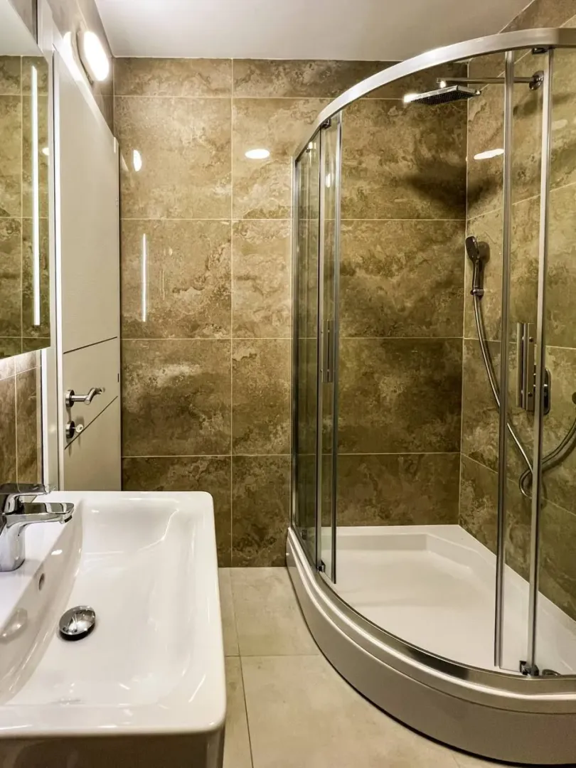 Modern bathroom with a shower cabin and a washbasin.