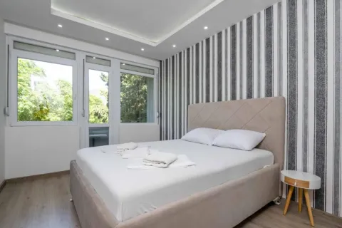 Bright bedroom with a double bed, patterned wallpaper, and access to the terrace. - image 5