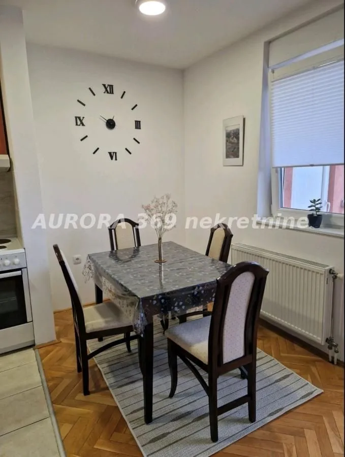 Dining area with a table, four chairs, and a wall clock.