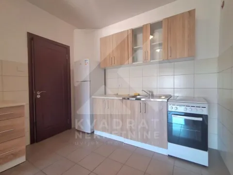 Manja kuhinja sa drvenim elementima, frižiderom i šporetom. - image 4