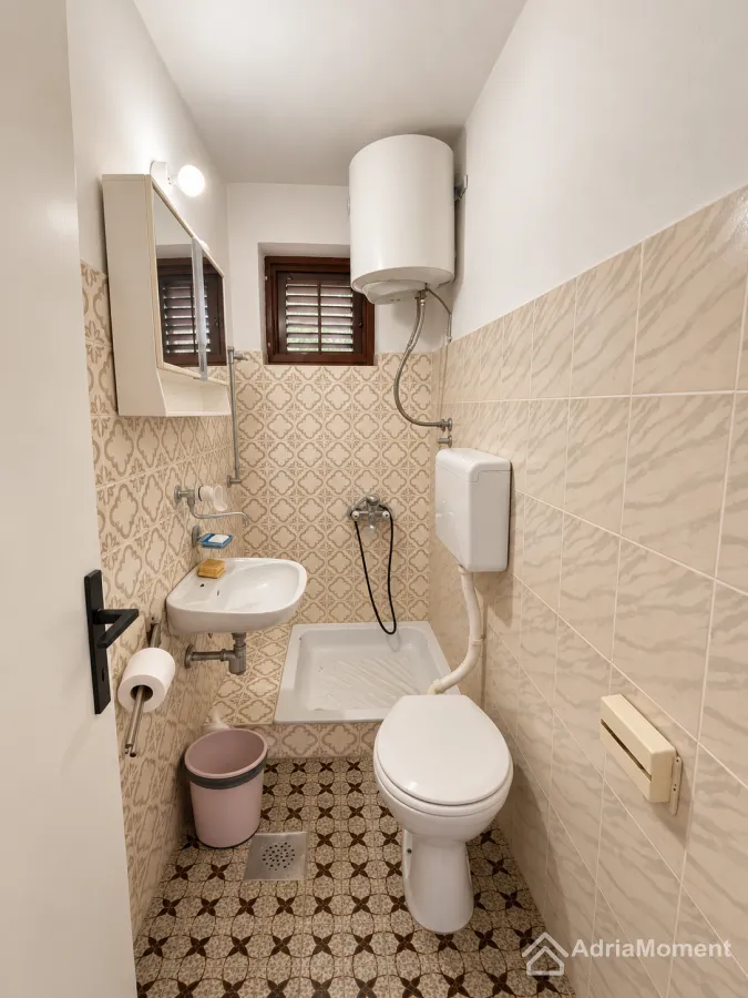 Manje kupatilo sa lavaboom, wc šoljom i tuš kadom.