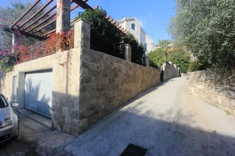 Prilaz kući sa garažom i kamenim zidom. - image 37