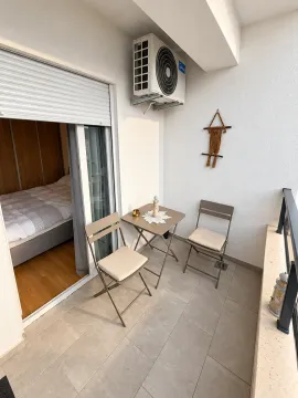 Small furnished balcony with a table and two chairs. - image 9