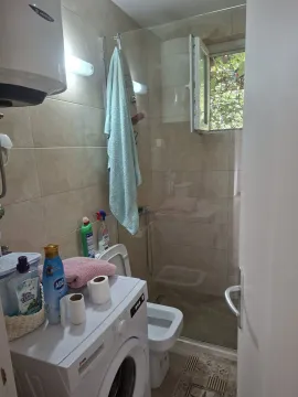 Bathroom with a shower cabin and a washing machine. - image 16