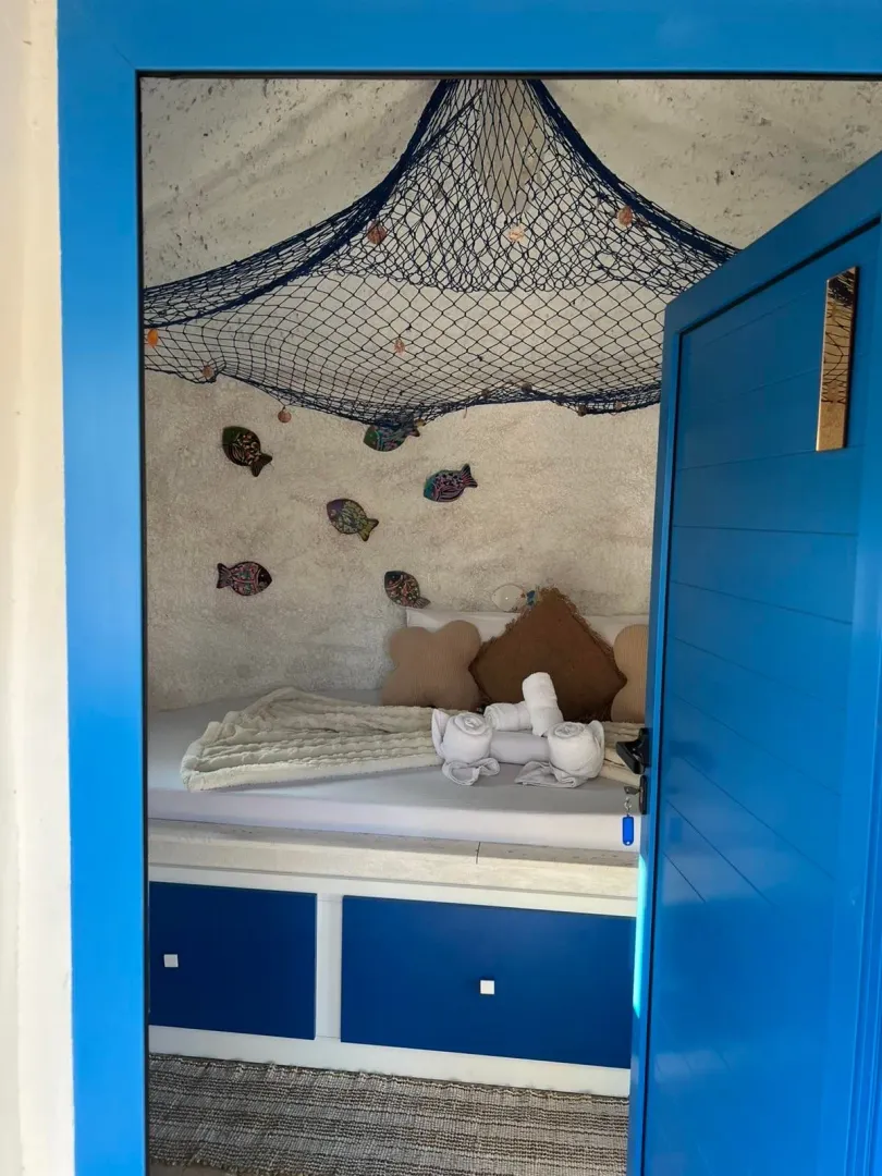 Uniquely decorated bedroom with nautical motifs and a blue door.