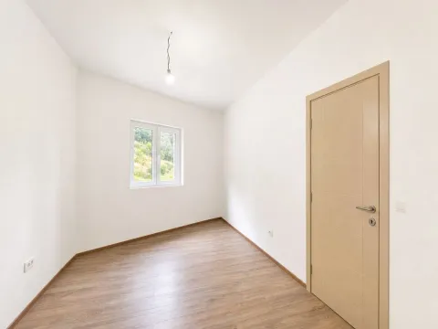 Prazna svijetla soba sa bijelim zidovima, drvenim podom i prozorom. - image 2