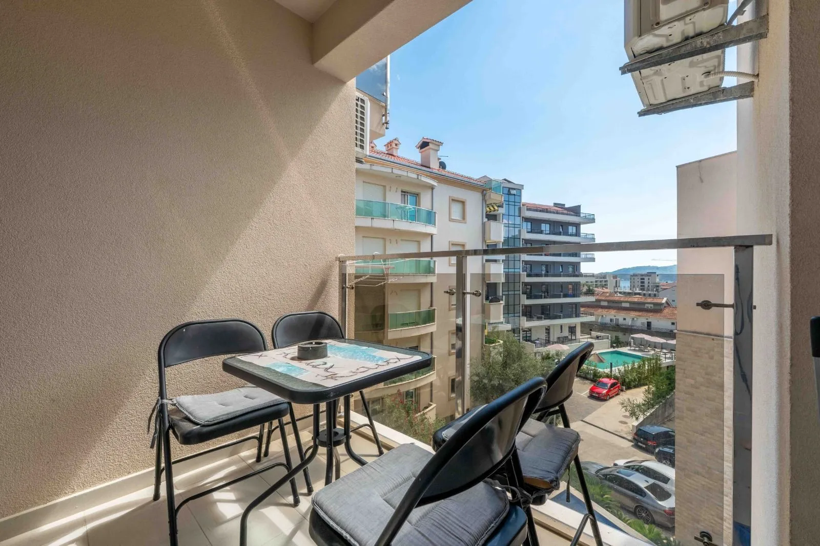 Covered terrace with a table and chairs and a view of the surrounding buildings and neighborhood.
