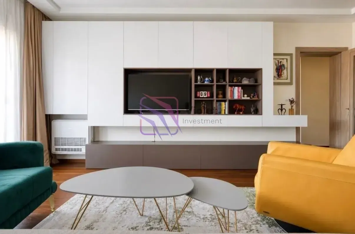 Living room with a large white TV unit and modern furniture.