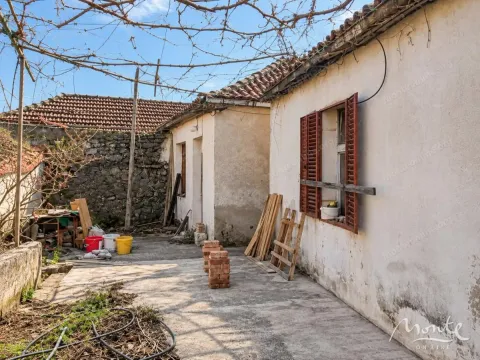 Pogled na dvorište i spoljašnjost starije kuće sa građevinskim materijalom. - image 4