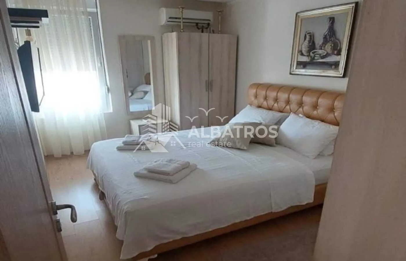 Furnished bedroom with a double bed, wardrobe, and air conditioning.