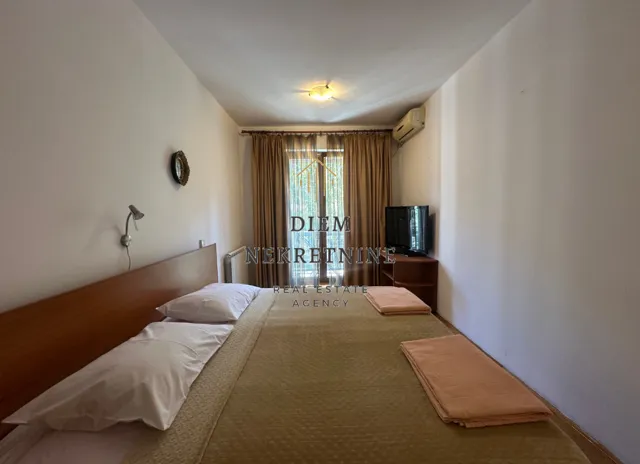 Bedroom with a double bed, TV, and access to the terrace.