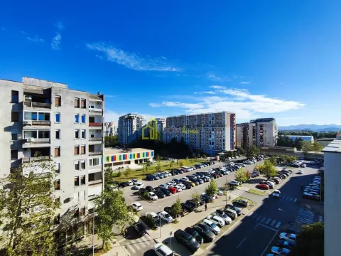 View from the window overlooking surrounding buildings and the parking lot in front of the building. - image 6