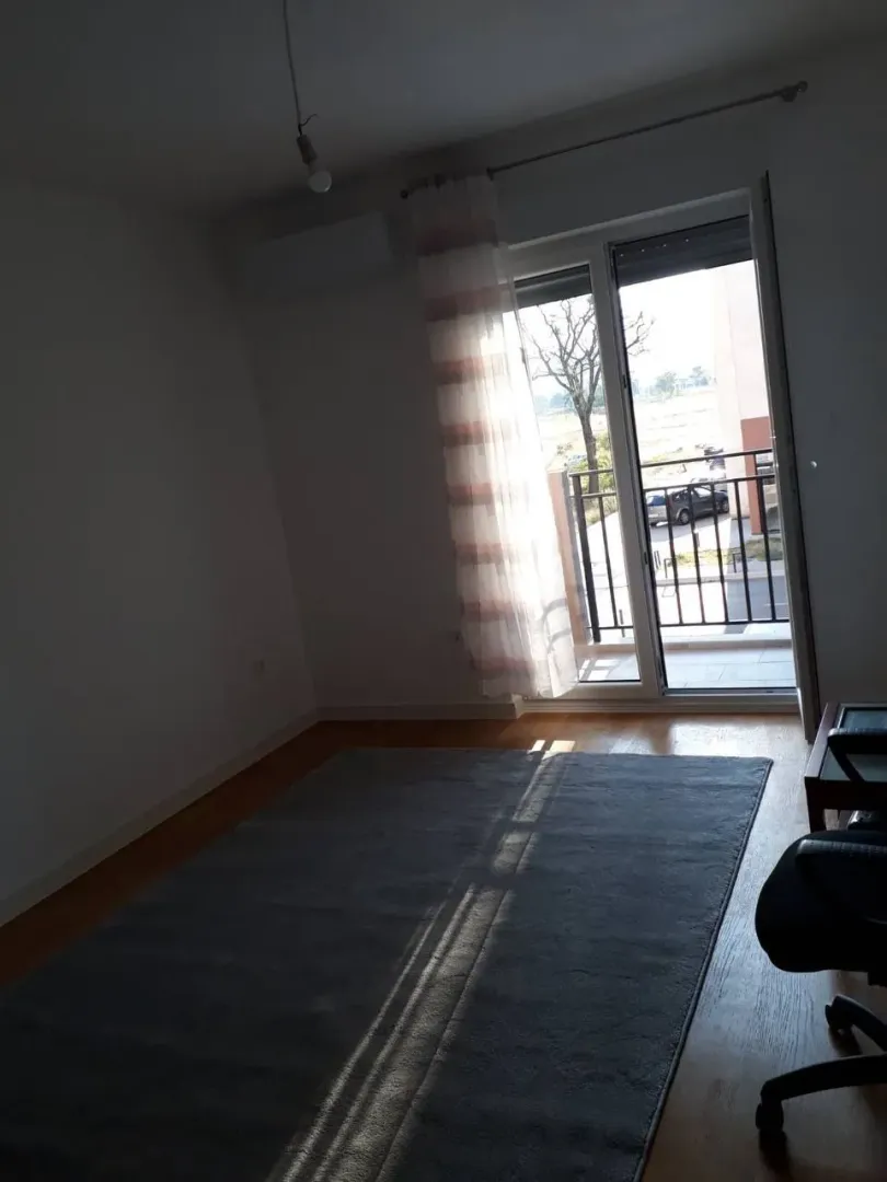 Empty room with a large window and access to the terrace.