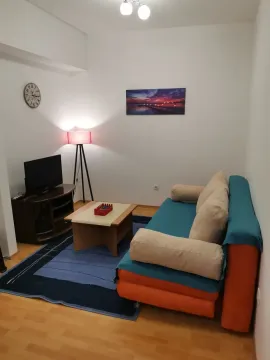 Bright living room with a sofa, television, and coffee table. - image 2