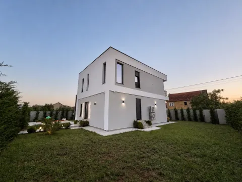Exterior view of a two-story house with a landscaped yard and lawn. - image 2
