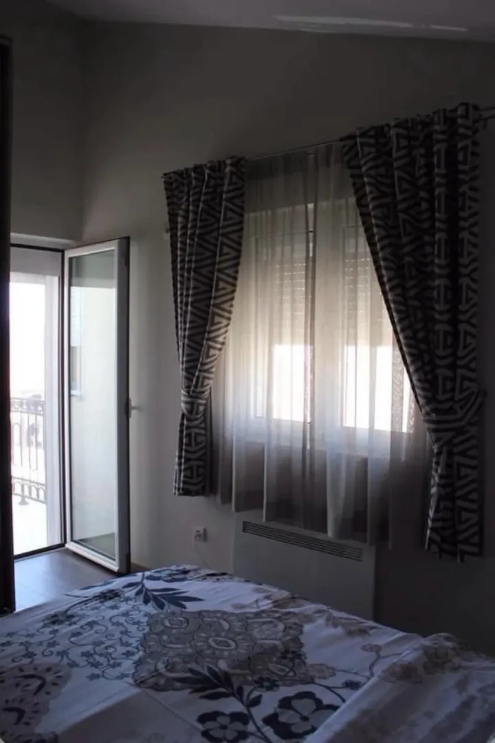 Bedroom with a bed, a window with curtains, and access to the terrace.