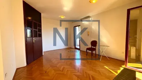 Prazna soba sa parketom, drvenim vratima i stolicom. - image 2
