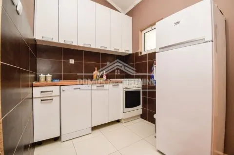 A simple kitchen featuring white cabinetry and a refrigerator. - image 5