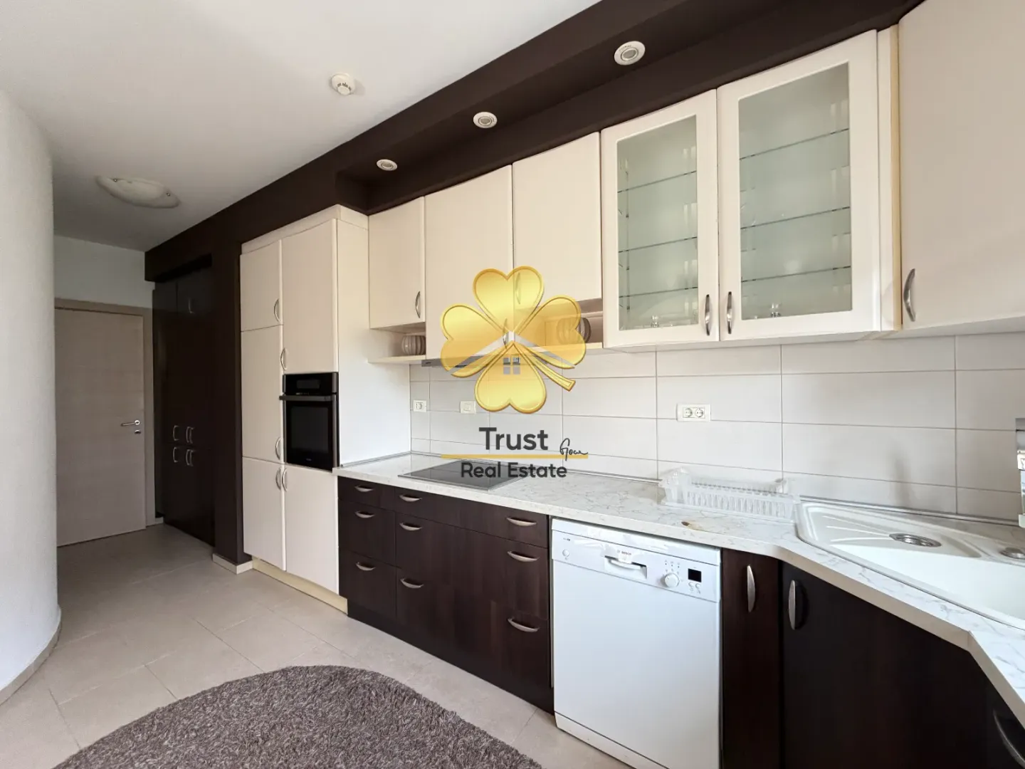 Modern kitchen with light upper and dark lower cabinets.