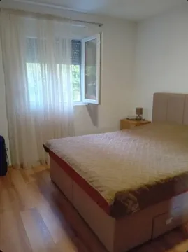 Spavaća soba sa bračnim krevetom i prozorom sa bijelim zavjesama. - image 9