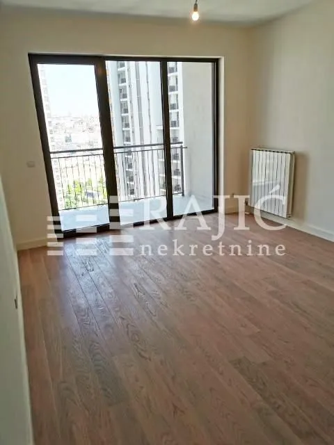 Empty room with hardwood floors and access to the terrace.