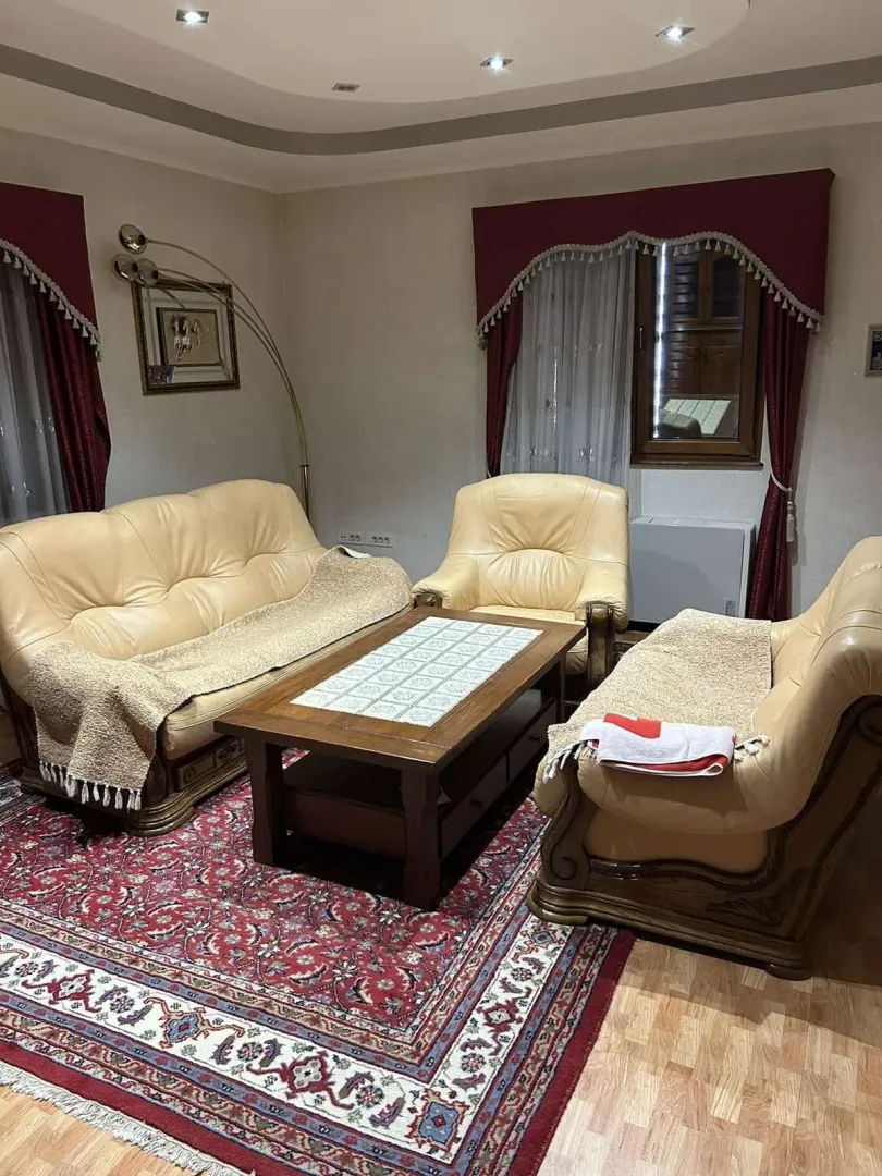 Living room with leather furniture and a wooden table.