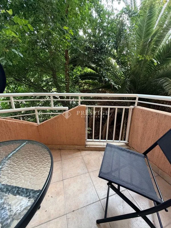 Furnished balcony with outdoor seating and green views.