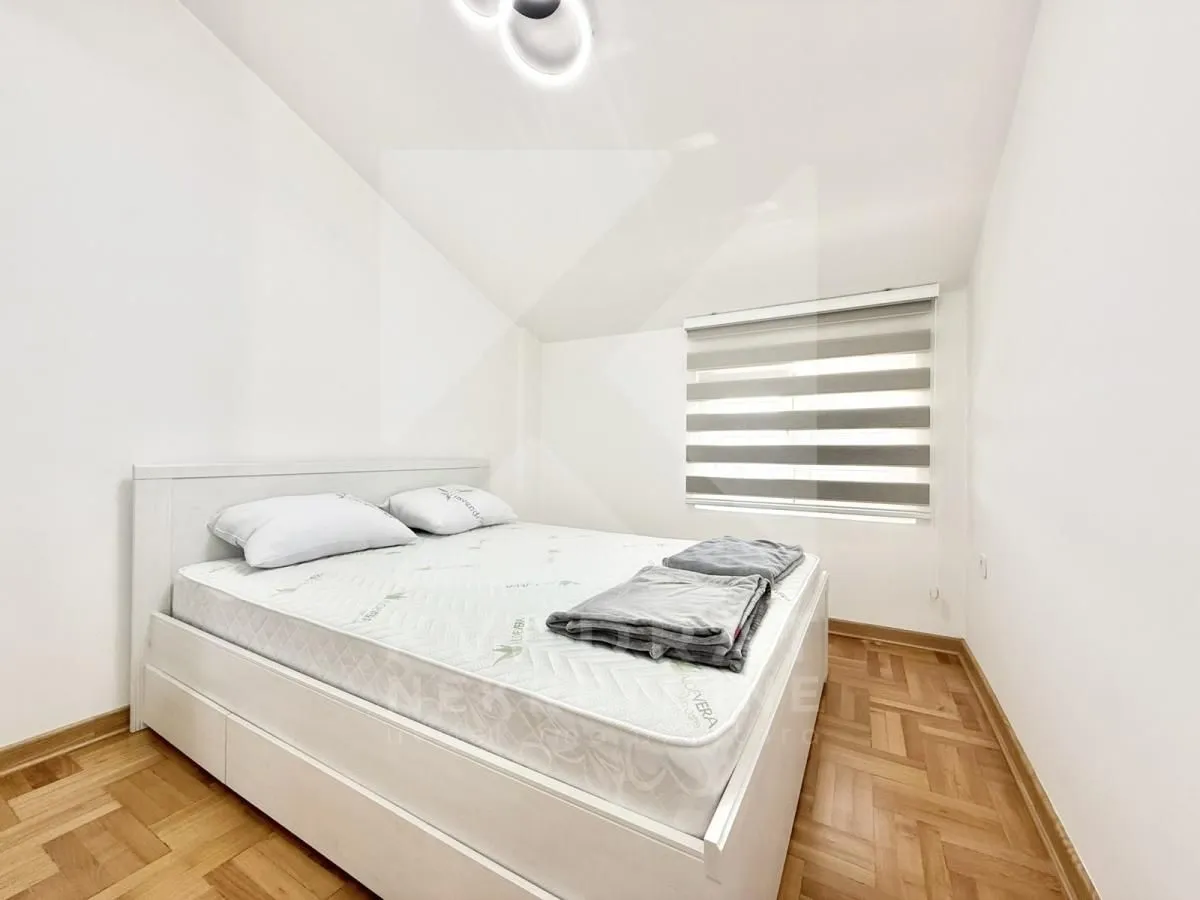 Bright bedroom with a double bed and parquet flooring.