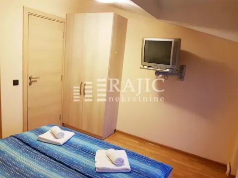 Furnished bedroom with a bed, wardrobe, and television. - image 8
