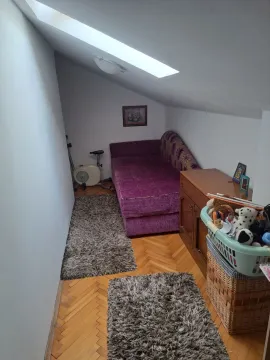 Potkrovlje opremljeno krevetom, komodom i sobnim biciklom. - image 8