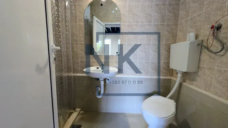 Smaller bathroom with a washbasin, mirror, and toilet.