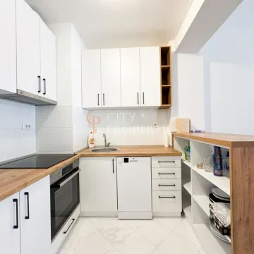 Manja bijela kuhinja sa drvenim radnim površinama i ugradnim uređajima. - image 11