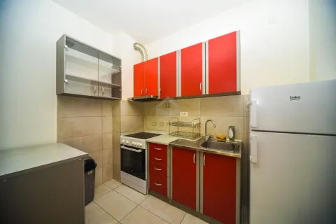 Small kitchen with red cabinets, stove, and refrigerator. - image 5