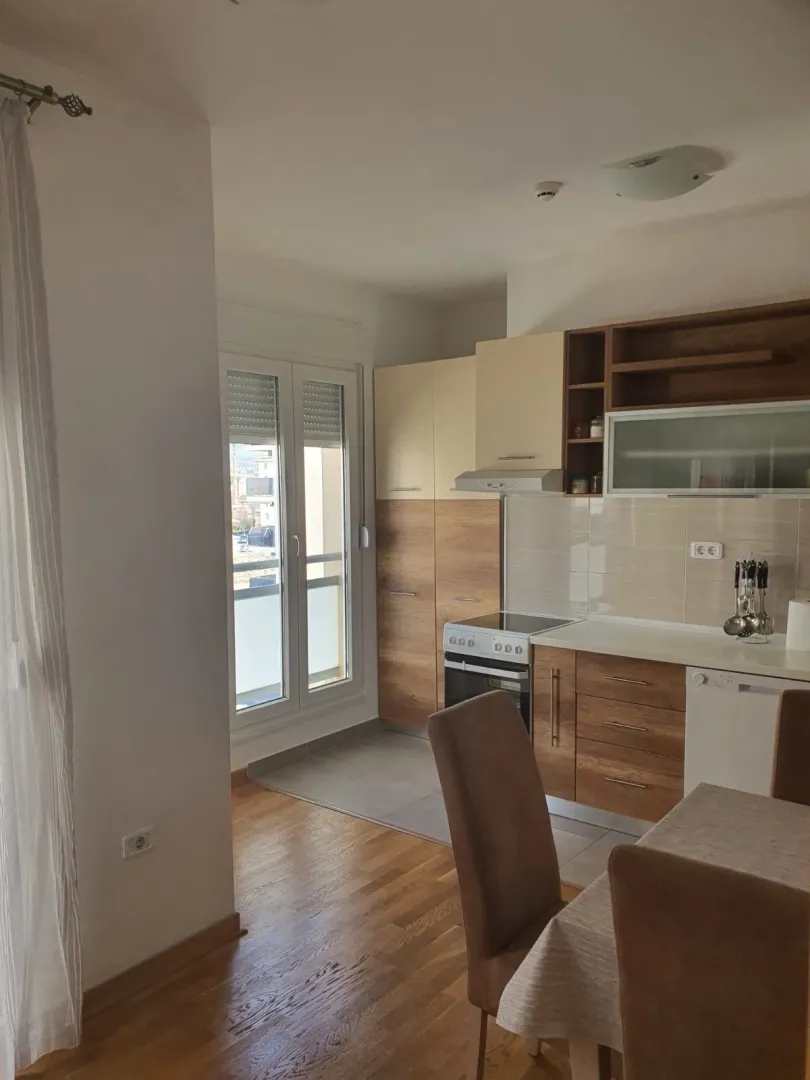 Modern kitchen with wooden elements and a dining table.