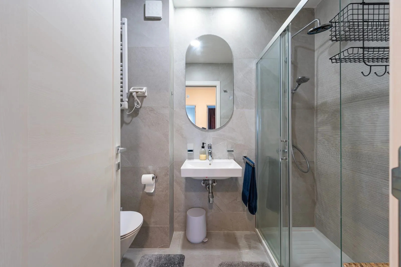 Modern bathroom with a shower cabin, washbasin, and toilet.