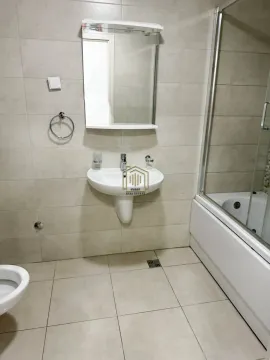 Bathroom equipped with a washbasin, mirror, bathtub, and toilet. - image 5