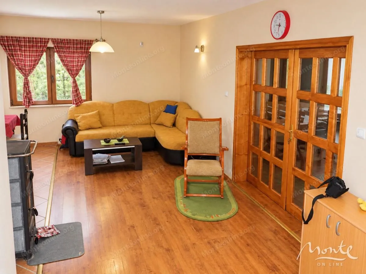 Living room with a sectional sofa, coffee table, and wooden doors.