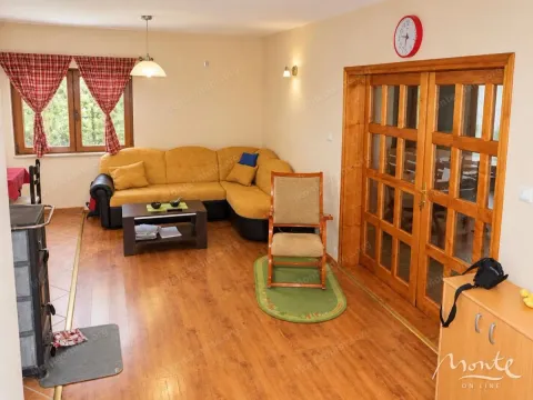 Living room with a sectional sofa, coffee table, and wooden doors. - image 2