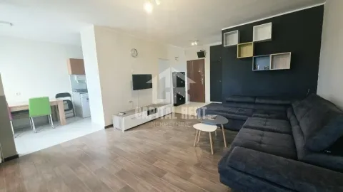Living room with a sofa, TV, and dining area in the background. - image 19