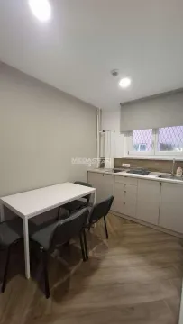 Small kitchen with a dining table and chairs. - image 11