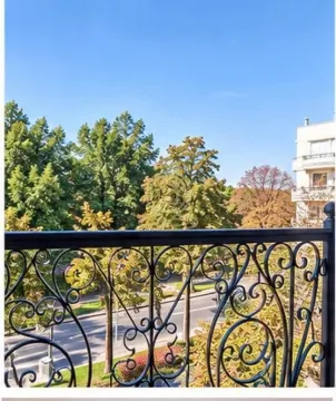 View from the balcony overlooking trees and the surrounding street. - image 7