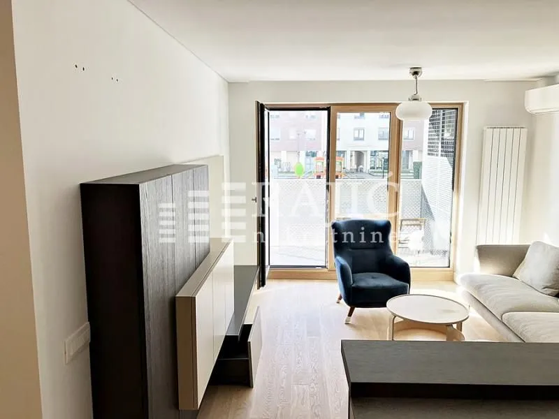 Bright living room with sofa and access to the terrace.