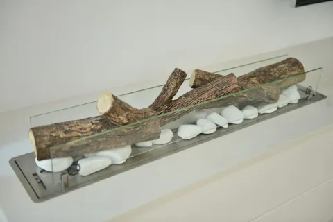 Detalj modernog kamina sa dekorativnim drvima i bijelim kamenčićima. - image 22