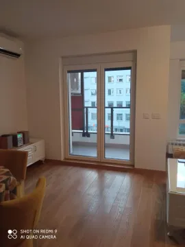 Living room with a view of the terrace and surrounding buildings. - image 6