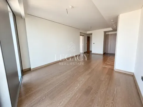 Prostrana prazna prostorija sa drvenim podom i belim zidovima. - image 17
