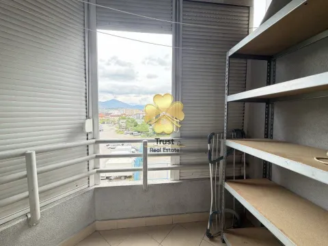 Enclosed balcony with metal shelves and a view of the neighborhood. - image 10
